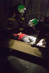 Bild: Ein Suchtrupp, ausger&amp;uuml;stet mit Atemschutzger&amp;auml;ten hat einen verletzten Arbeiter gefunden und lagert ihn auf eine Trage um