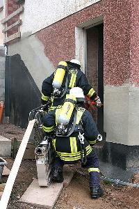 Bild: Ausger&amp;uuml;stet mit Atemschutzger&amp;auml;ten dring ein Trupp in der verrauchte Haus vor (Foto: Heike Blum)