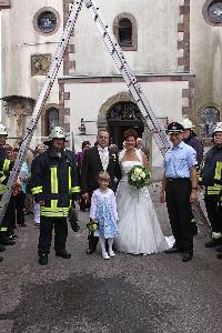 Bild: Das frischverm&amp;auml;hlte Brautpaar mit den Feuerwehrkameraden vor der Pfarrkirche in Eppelborn