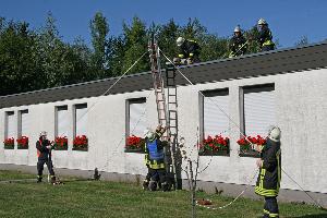 Bild: Eine Person wird mit einem sogenannten Leiterhebel vom Dach des Geb&amp;auml;udes gerettet