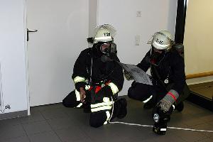 Bild: Mit Hilfe von Feuerwehr-Laufkarten durchsucht ein Trupp unter umluftunabhängigem Atemschutz das Gebäude