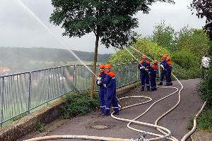 Bild: Mit mehreren Rohren bek&amp;auml;mpfen die Jugendfeuerwehrleute die angenommenen Fl&amp;auml;chenbrand