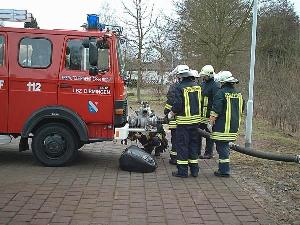 Bild: Eine Gruppe &amp;uuml;bt an der Vorbaupumpe des LF 8 die Wasserentnahme aus offenen Gew&amp;auml;sser.