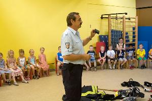 Bild: Wehrführer Hermann Josef Recktenwald zeigte den Kindern den Funkmeldeempfänger, mit dem die Feuerwehrleute zum Einsatz gerufen werden