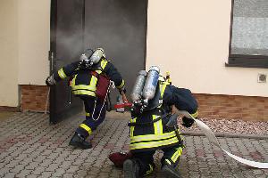 Bild: Ein Trupp dringt mit Atemschutzgeräten in die völlig verqualmte Halle vor (Foto: Feuerwehr Lebach)