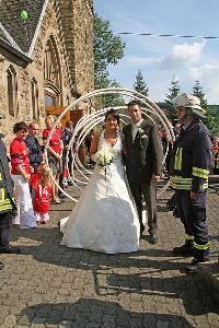 Bild: Arbeitskollegen der Berufsfeuerwehr warteten mit einem Schlauchspalier vor der Pfarrkirche in Sotzweiler auf das Brautpaar