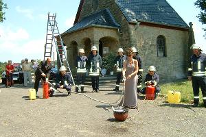 Bild: Einsatz der Braut beim Löschen der Flammen mit einer Kübelspritze