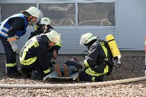 Bild: Eine gerettete Person wird den Helfern vor der Halle &amp;uuml;bergeben