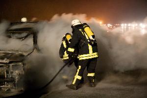 Bild: Löscharbeiten am Fahrzeug unter Atemschutz