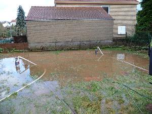 Bild: Das Wasser trat über das Bachbett und drohte in die Keller der anliegenden Wohnhäuser zu laufen