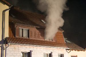 Bild: Rauch dringt aus einem Fenster im Obergeschoss des Wohnhauses