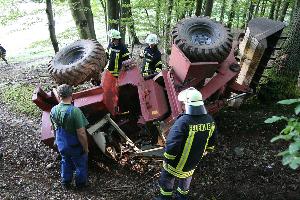 Bild: Feuerwehrleute begutachten den umgestürzten Radlader