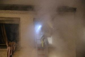 Bild: Ein Trupp geht &amp;uuml;ber eine Steckleiter ins Obergeschoss des Wohnhauses vor