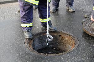 Bild: Ein Messgerät wird in die Kanalisation heruntergelassen