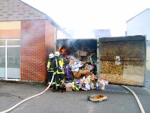 Bild: Noch immer sind Flammen im Container zu erkennen