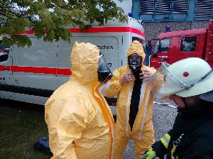 Bild: Ankleiden der Einsatzkräfte mit Schutzkleidung