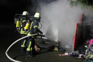 Bild: Unter Atemschutz l&amp;ouml;schte ein Trupp die brennenden Altkleidercontainer